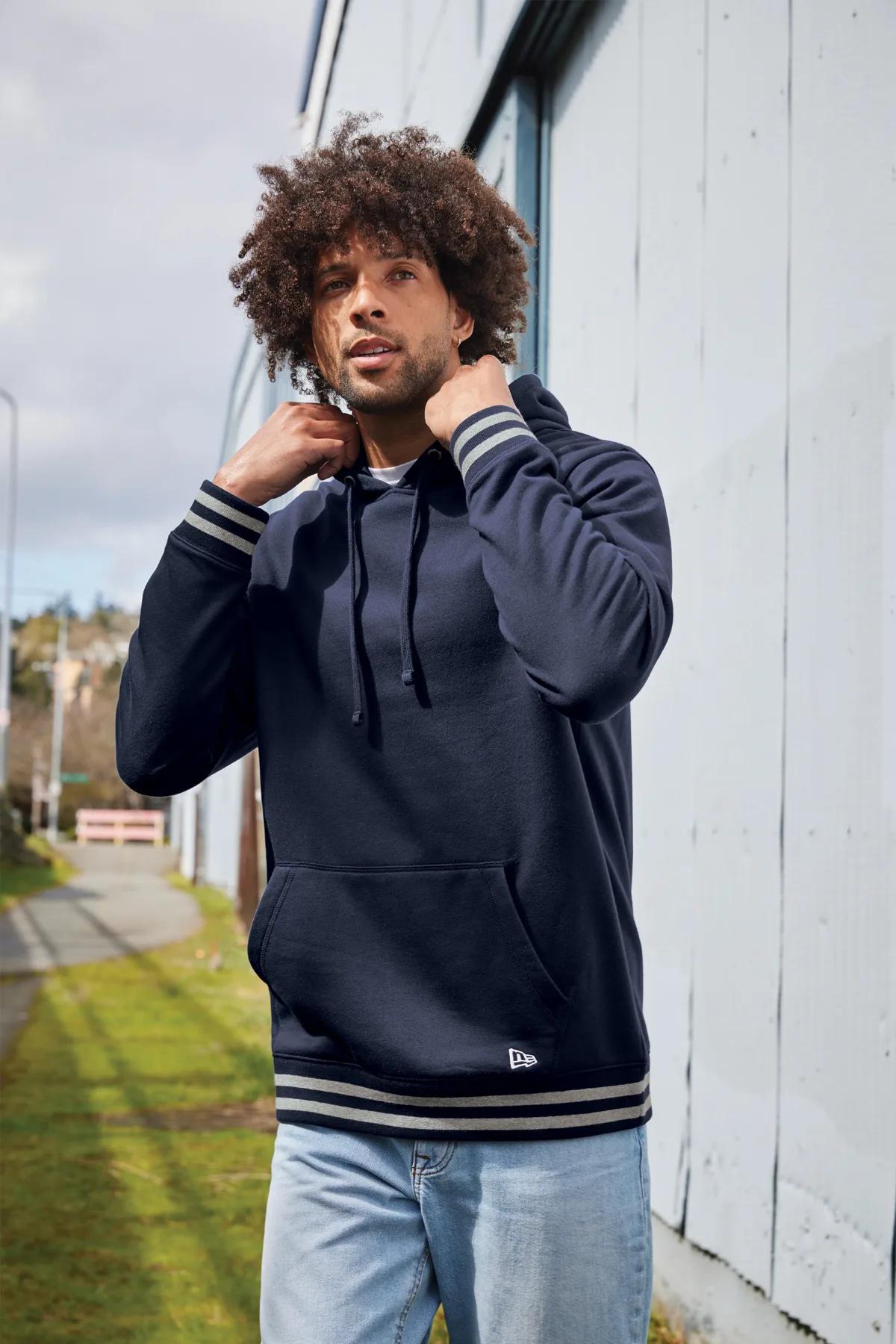 Man wearing a navy New Era Comeback pullover hoodie outdoors
