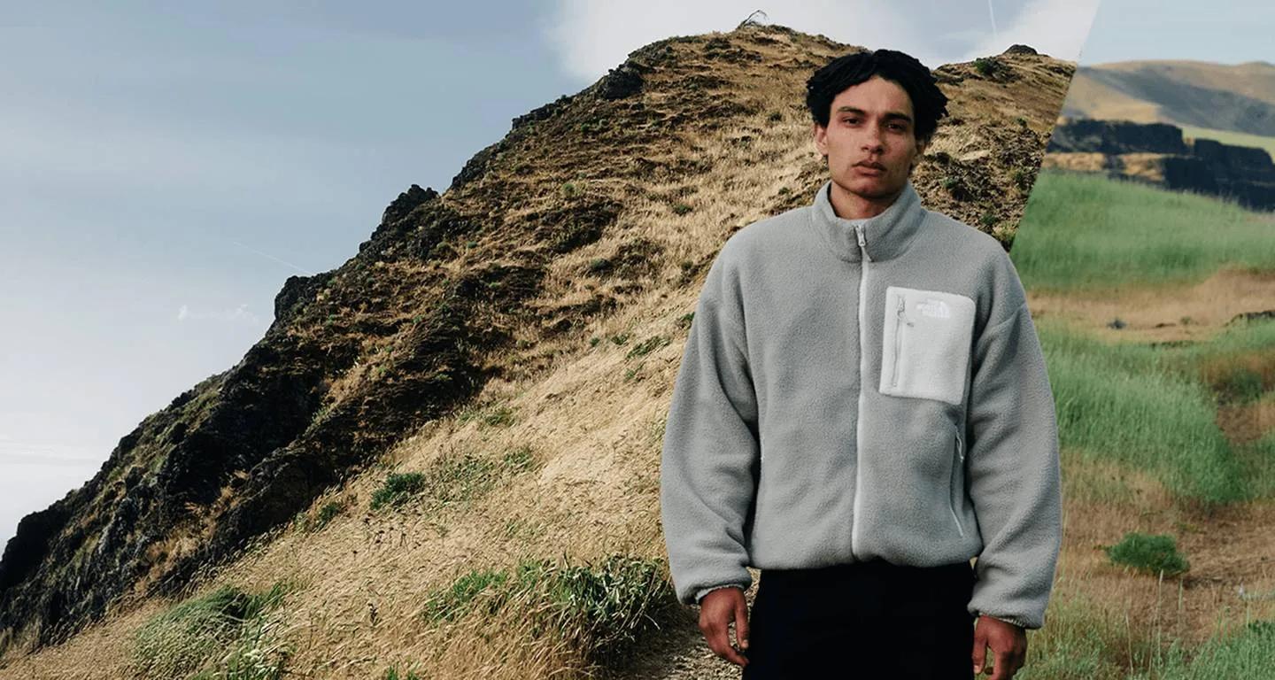 Man in a grey North Face fleece on a grassy ridge